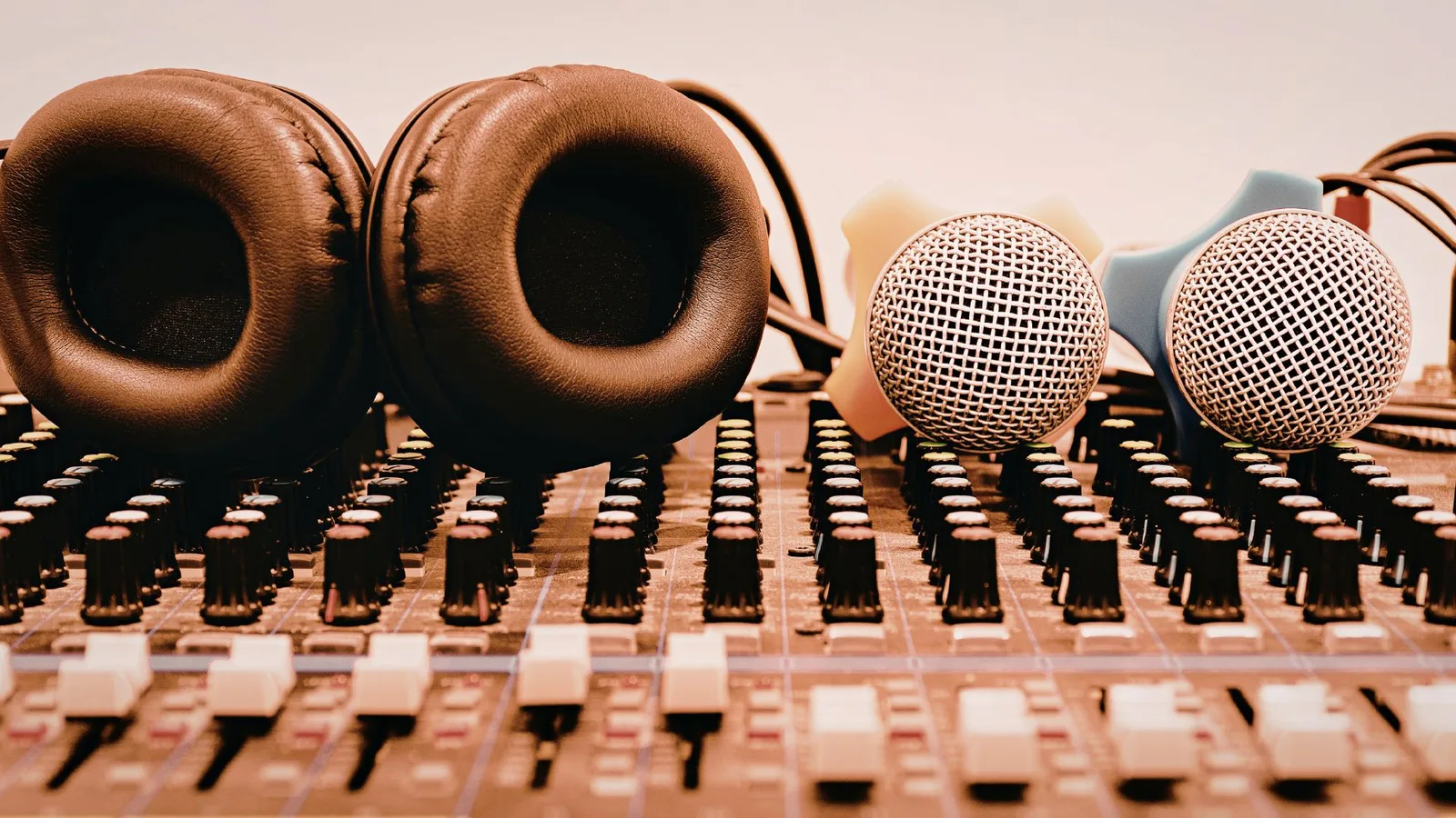 Headphones and microphones on a sound mixing console.
